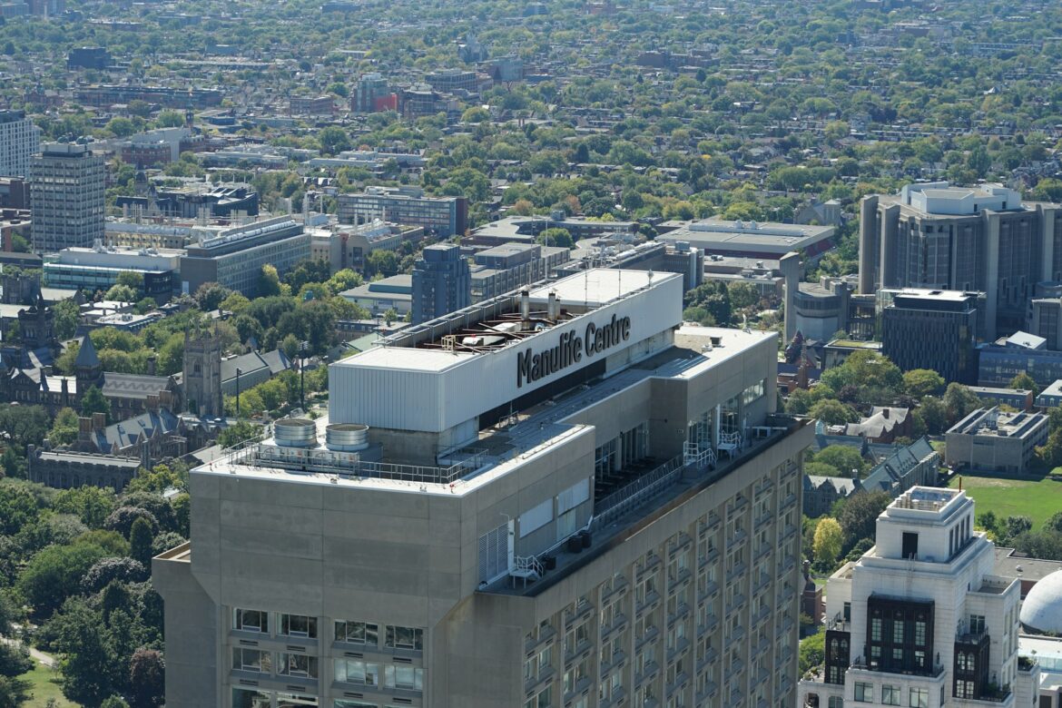 Aerial view of the Manulife Centre rooftop with the city skyline and green spaces beyond.