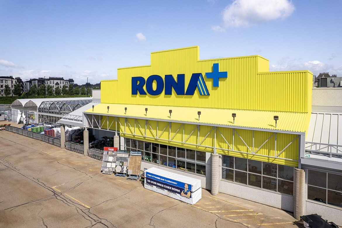 Exterior of a yellow RONA+ store with a blue sign, carts and loading area outside.