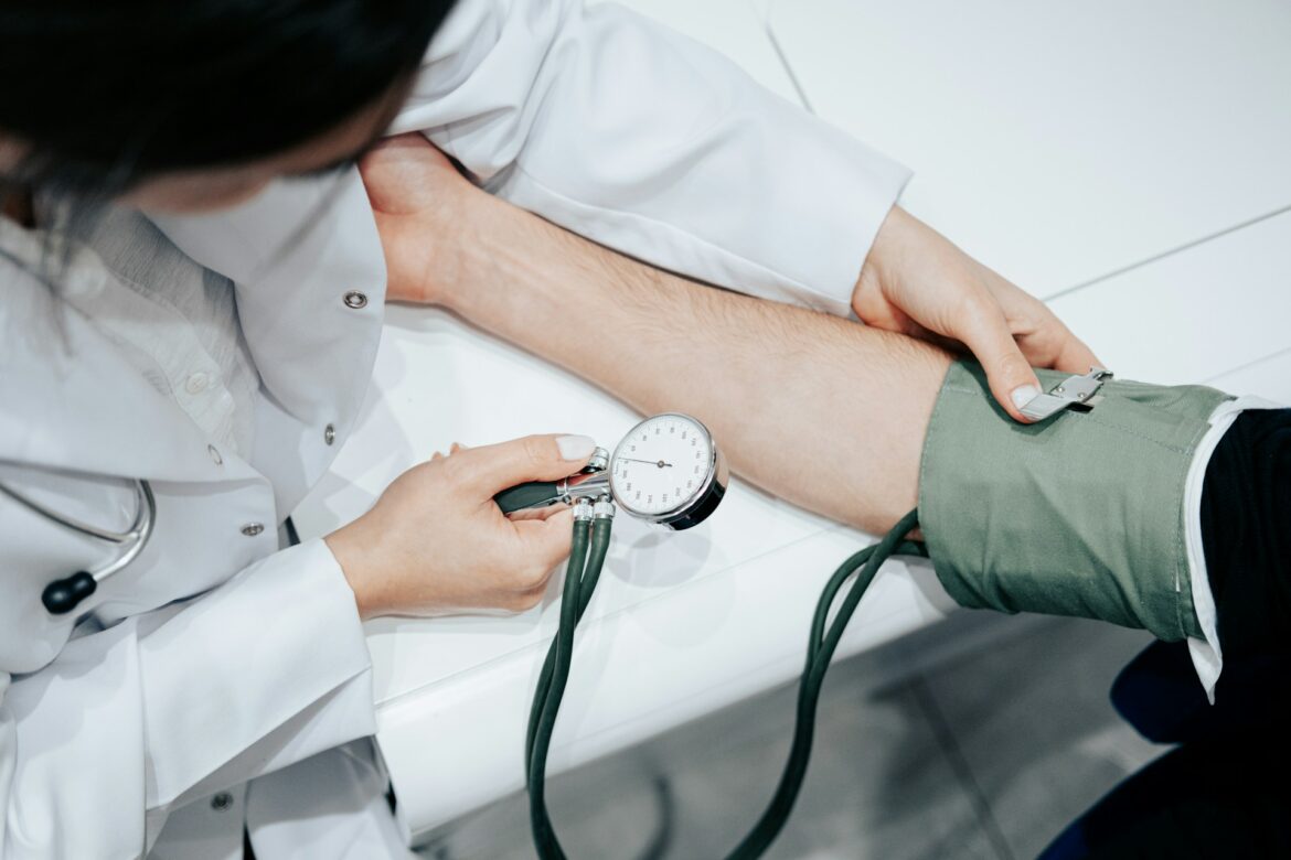 Healthcare professional measuring a patient's blood pressure with a cuff and manometer on the arm