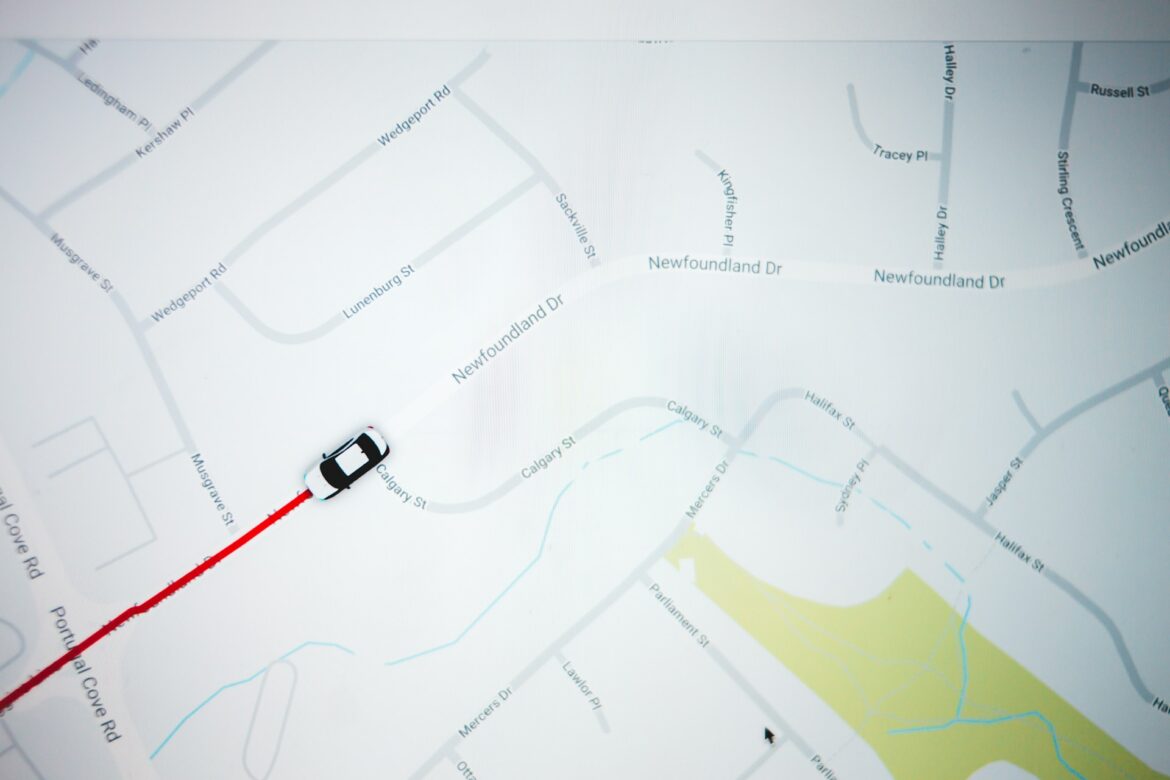 Top-down map view with a white car following a red route along Newfoundland Drive near Calgary Street in a residential area.