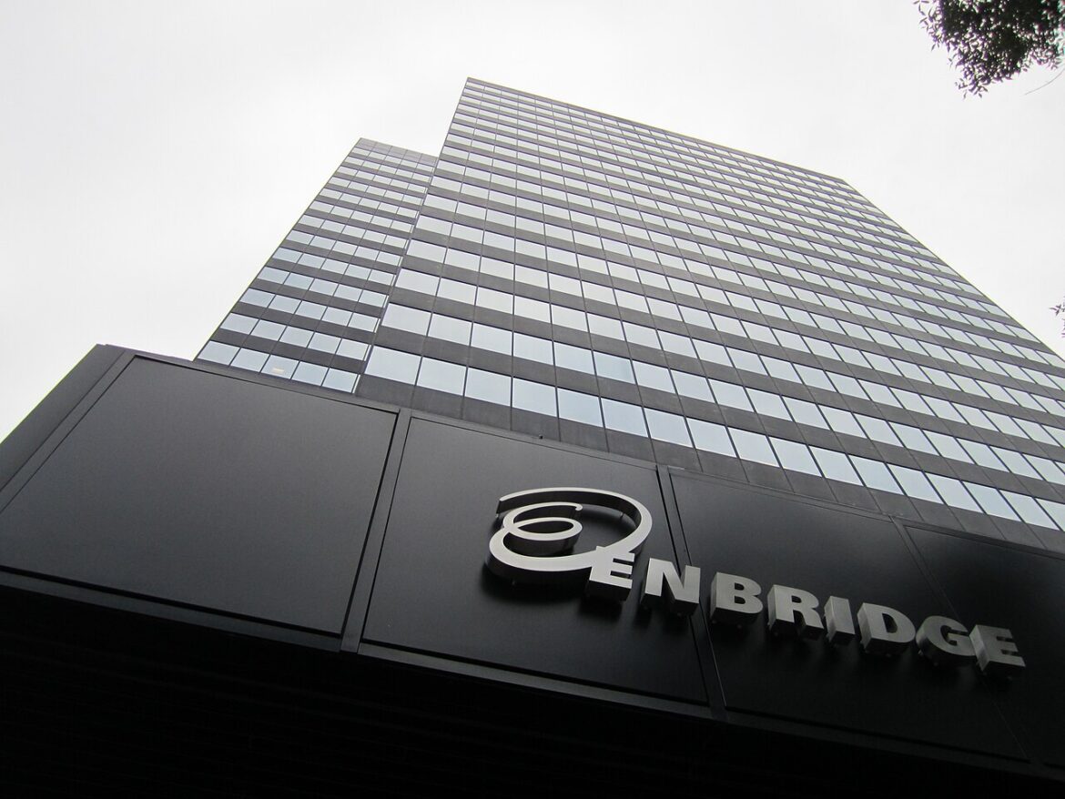 Low-angle shot of a glass-clad skyscraper with the Enbridge logo on the dark facade.