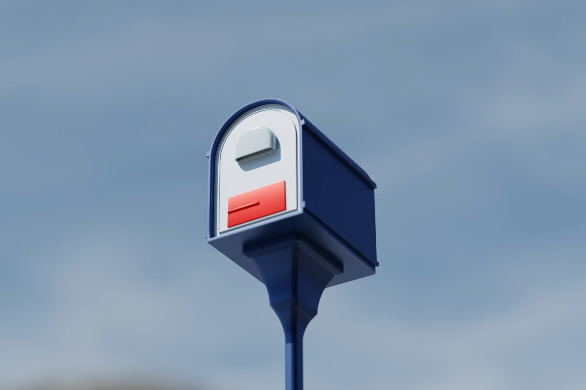 Blue post holding a white curved mailbox with a red flag, set against a clear blue sky.